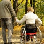 Man and woman on a wheelchair in the park
