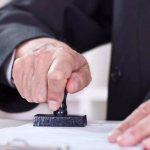 The notary puts a stamp on the document