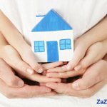 Family holding a paper house