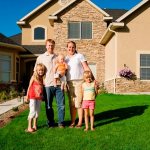 Family on the lawn with a house in the background
